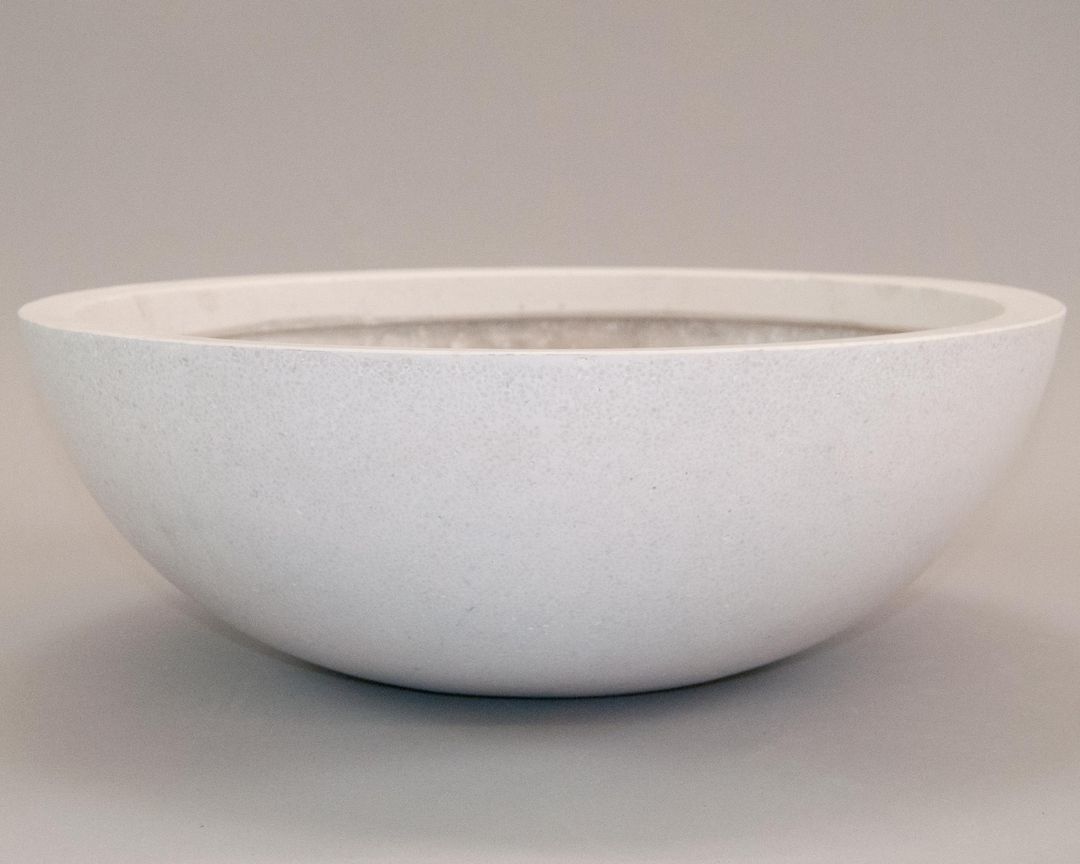 Runde Pflanzschale aus Fiberglas in Perlmuttweiß mit feiner Sprenkelung vor grauem Hintergrund