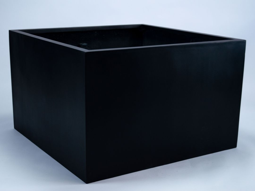 Niedriger quadratischer Pflanzkübel aus Fiberglas in Schwarz-matt, schräg von oben vor hellgrauem Hintergrund