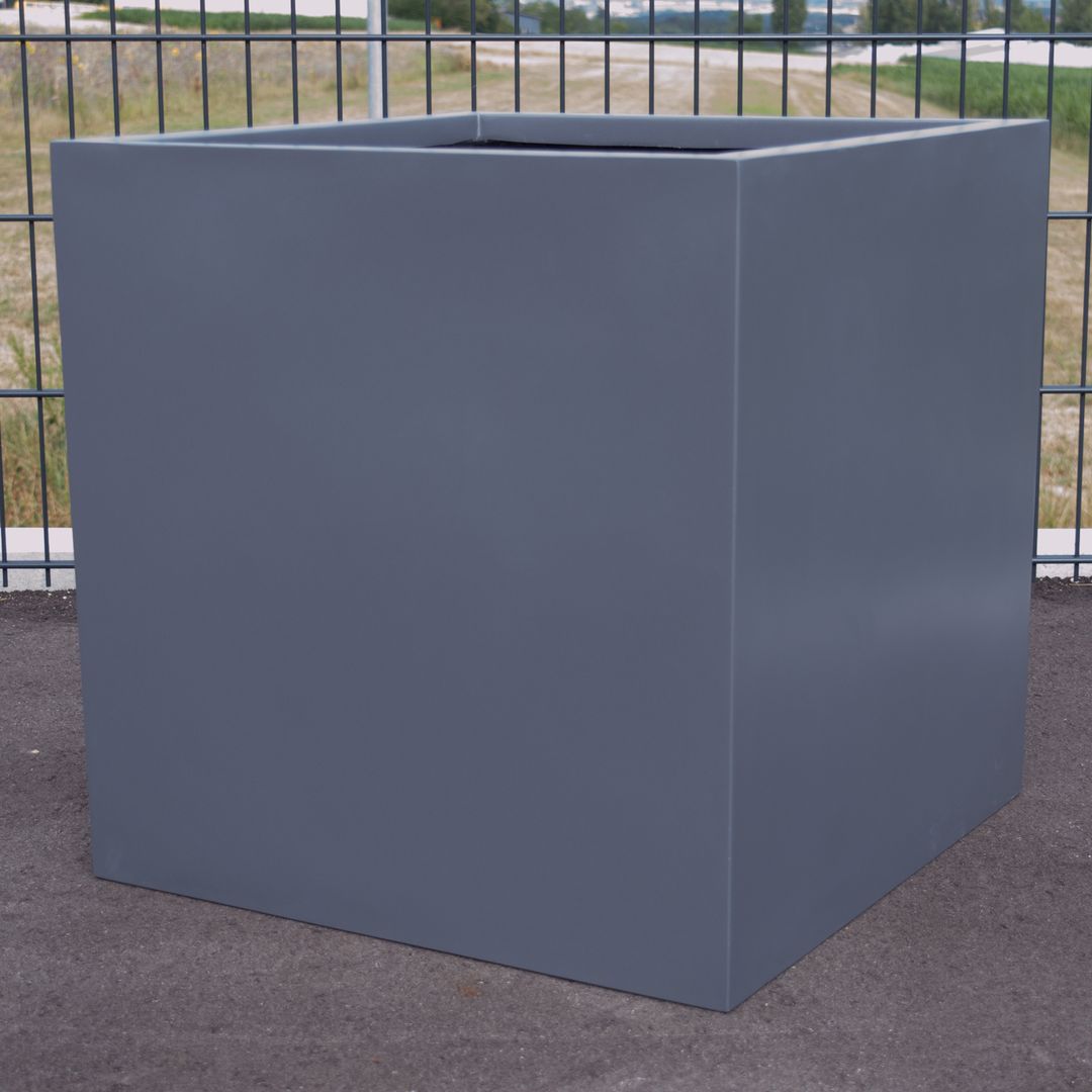 Quadratischer Pflanzkübel aus Fiberglas in Anthrazit metallic ohne Bepflanzung vor einem Metallzaun im Freien