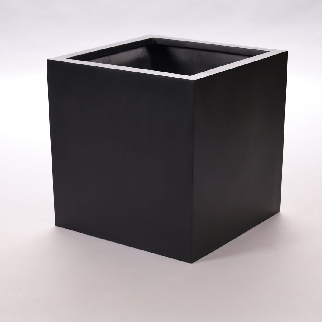 Quadratischer Pflanzkübel aus Fiberglas in Schwarz-matt, leer und schräg von oben vor hellgrauem Hintergrund