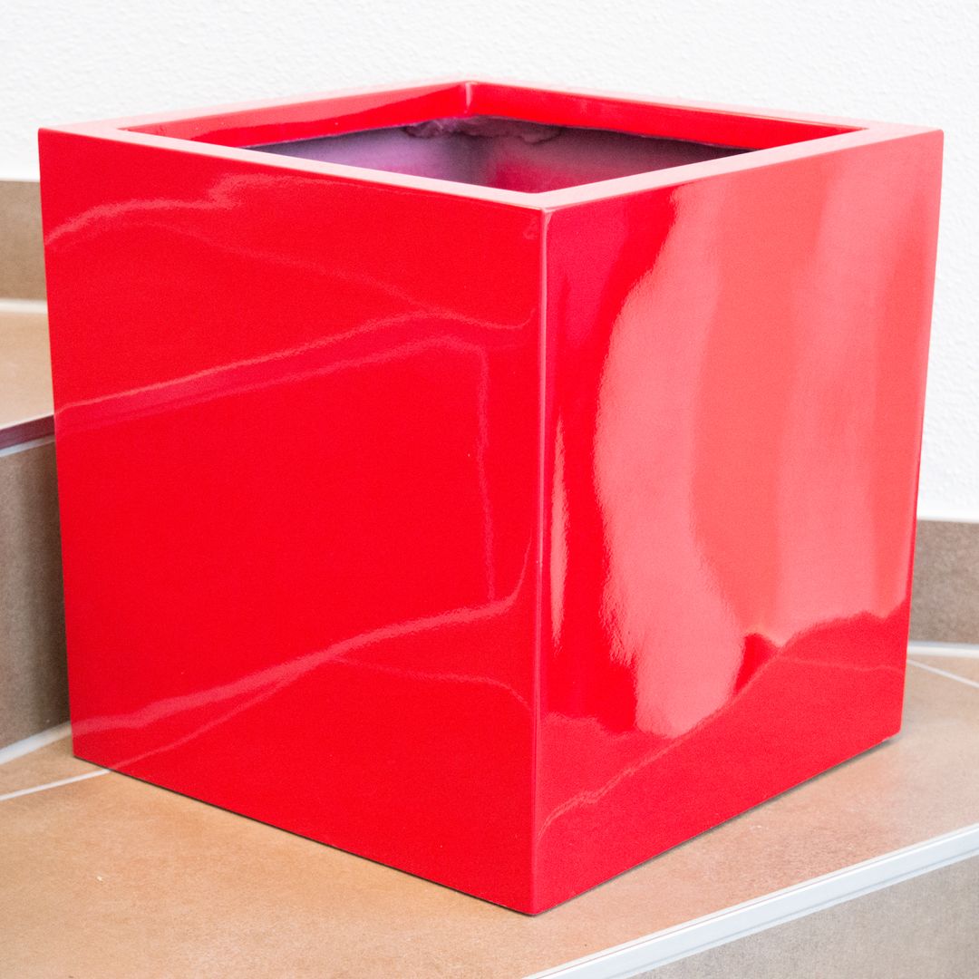 Quadratischer Pflanzkübel aus Fiberglas in Hochglanz Rot ohne Bepflanzung auf einer Treppenstufe mit Fliesen