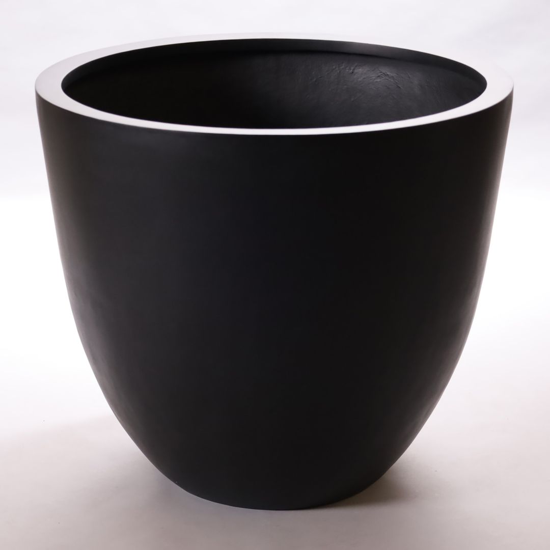 Runder konischer Pflanzkübel aus Fiberglas in Schwarz-matt mit abgerundeter Form vor hellem Hintergrund