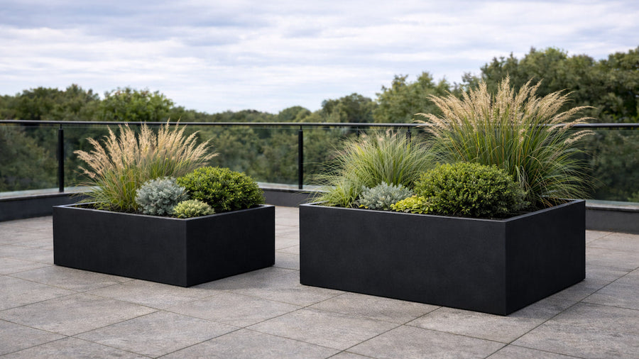 Quadratische Pflanzkübel in Schwarz auf Outdoor-Terrasse — Referenzbild