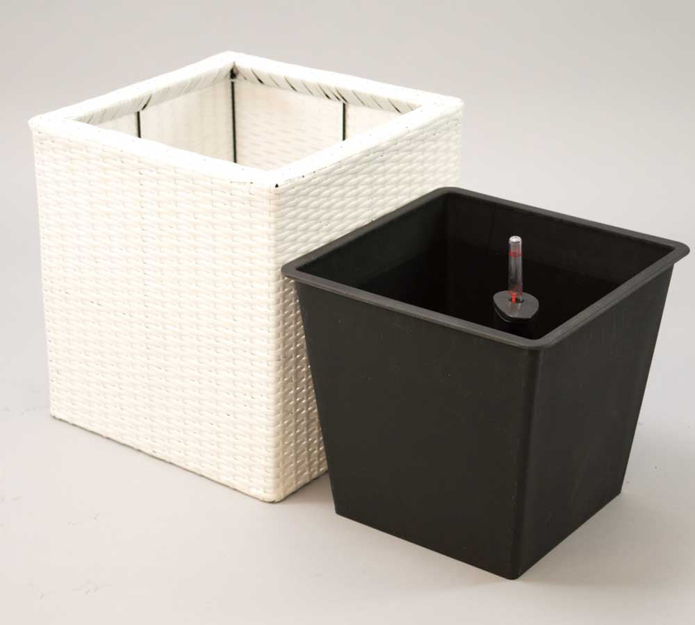 Weißer quadratischer Pflanzkübel aus Polyrattan neben schwarzem Kunststoffeinsatz mit Wasserstandsanzeiger