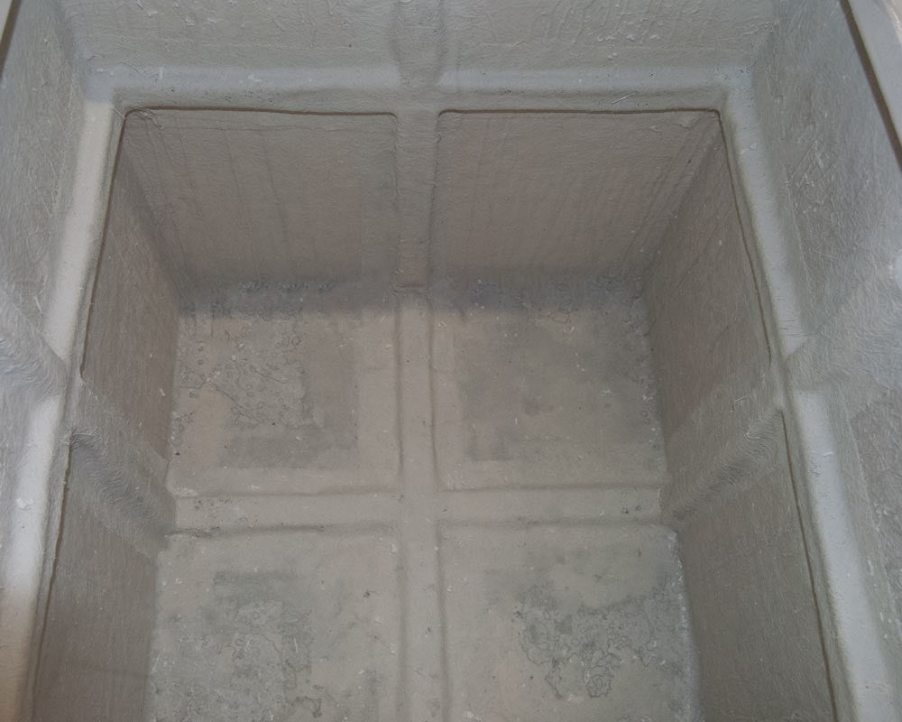 Blick von oben in das Innere eines quadratischen Pflanzkübels aus Fiberglas mit kreuzförmigen Rippen am Boden