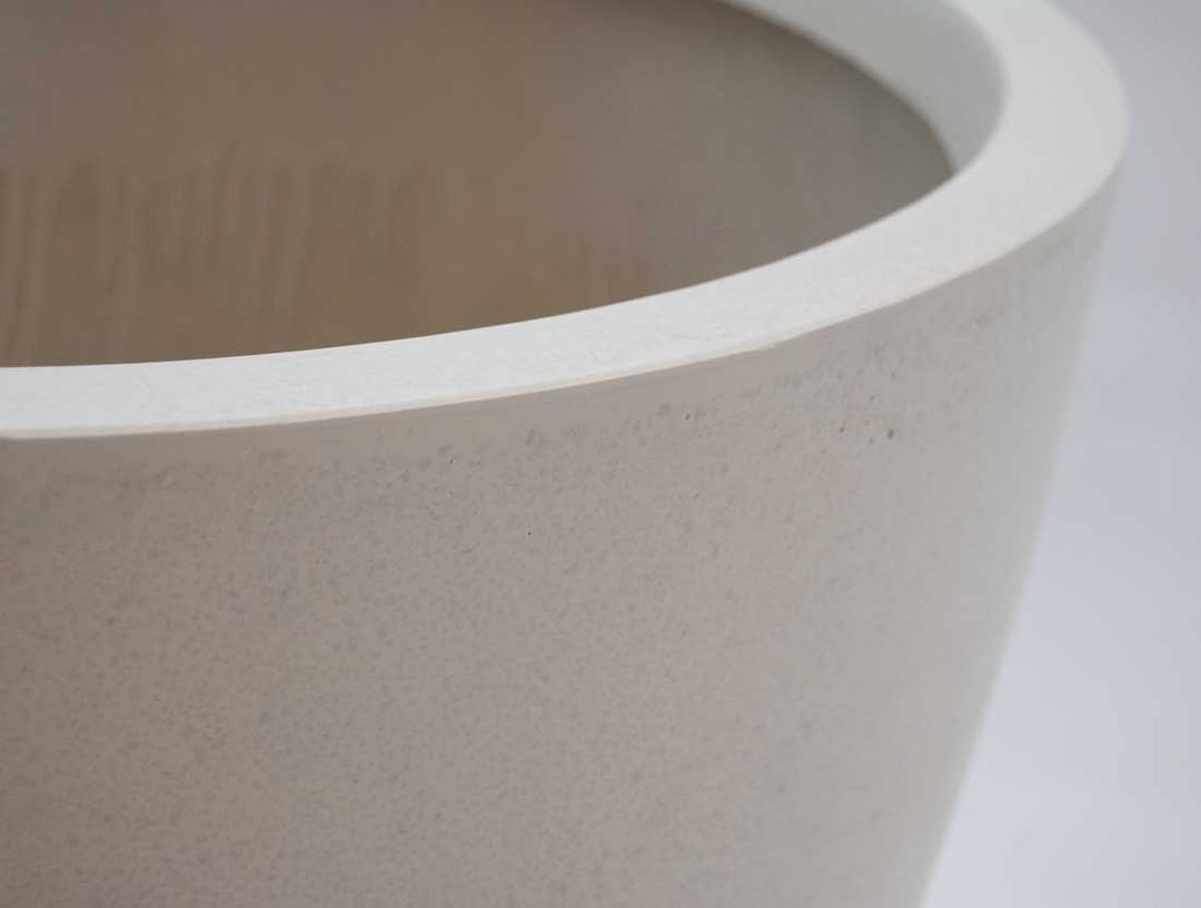 Nahaufnahme von Rand und Oberfläche eines runden konischen Pflanzkübels aus Fiberglas in Perlmuttweiß