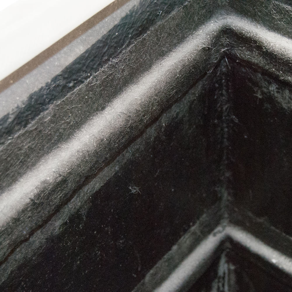 Detailansicht der Innenecke eines rechteckigen Pflanzkübels aus Fiberglas mit dunkler Innenseite und grauem Rand