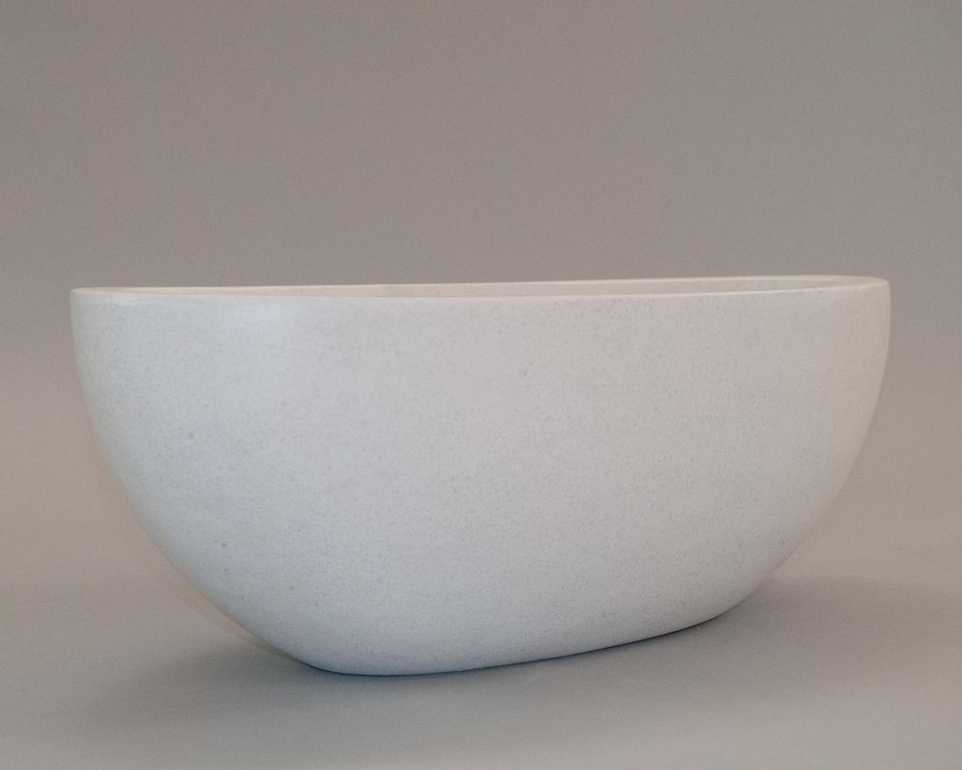 Ovaler Pflanzkübel aus Fiberglas in Perlmuttweiß mit fein gesprenkelter Oberfläche vor grauem Hintergrund