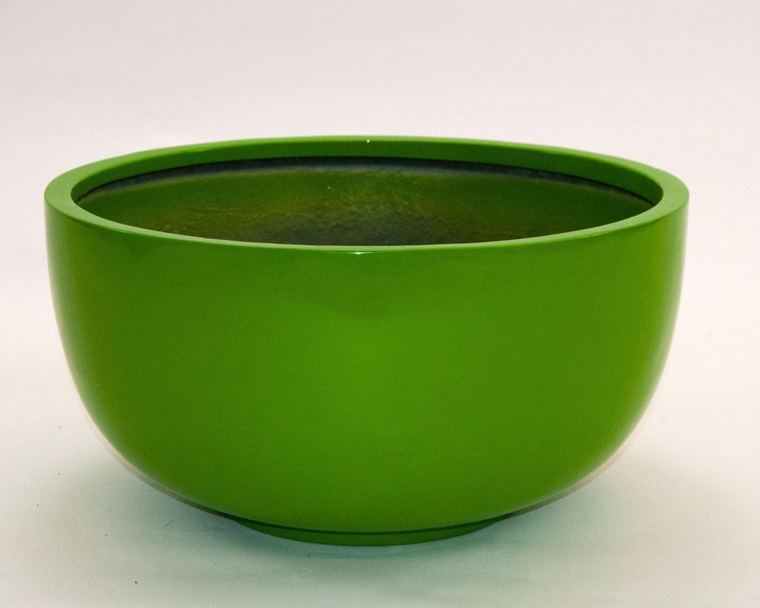 Runde Pflanzschale aus Fiberglas in Hochglanz-Avocadogrün mit dunkler Innenseite vor hellem Hintergrund