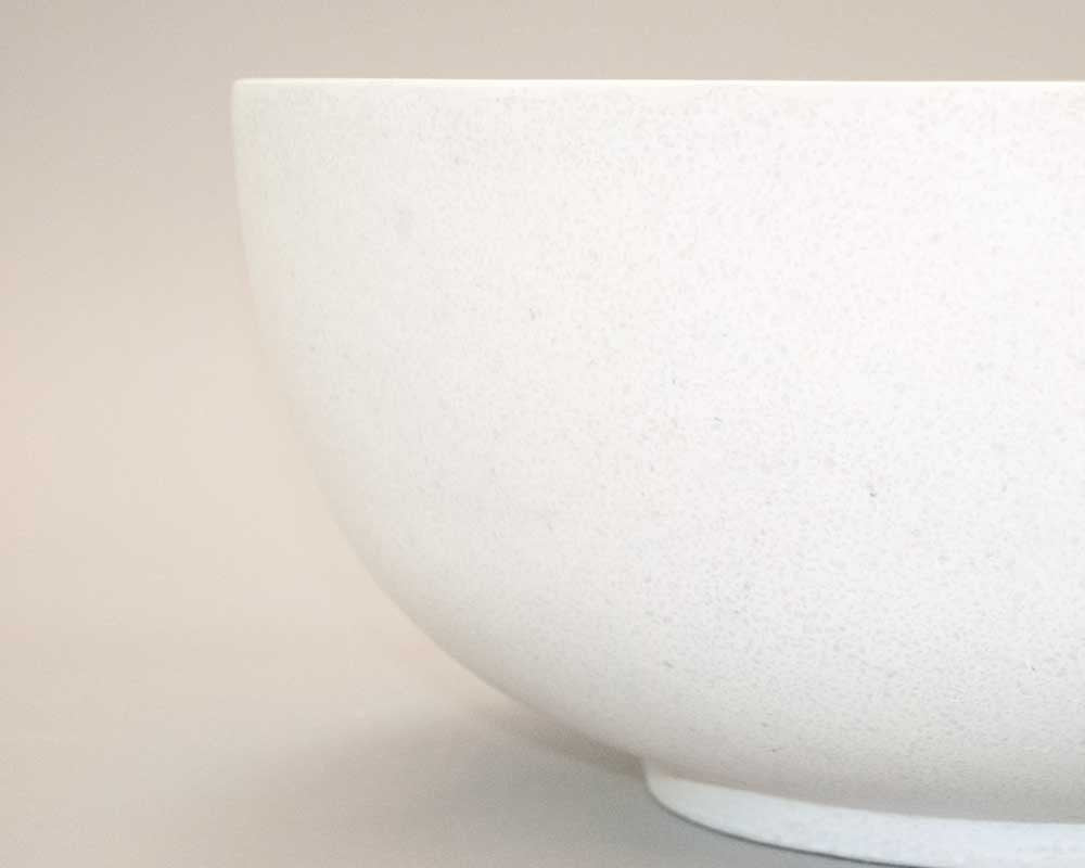 Detailansicht einer runden Pflanzschale aus Fiberglas in Perlmuttweiß mit gewölbter Wand und schmalem Standfuß