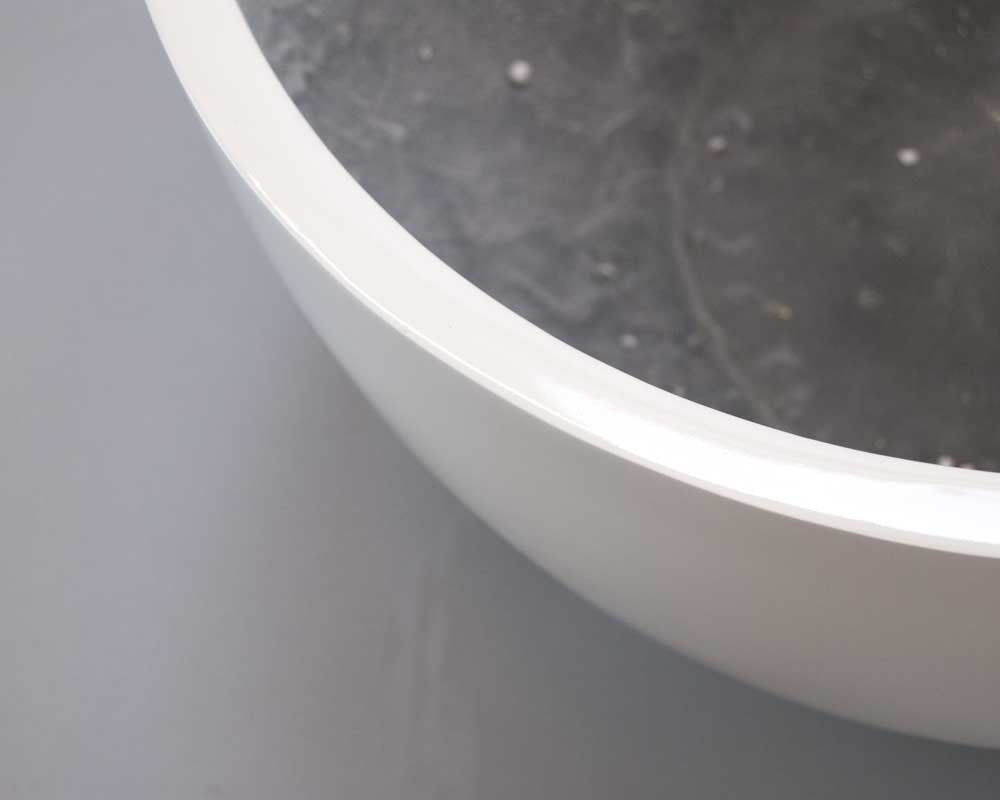 Nahaufnahme vom glänzenden Rand einer runden Pflanzschale aus Fiberglas in Hochglanz Weiß mit Blick ins dunkle Innere