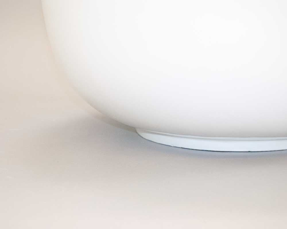Detailansicht des gewölbten Bodens einer runden weißen Pflanzschale aus Fiberglas mit abgesetztem Standring
