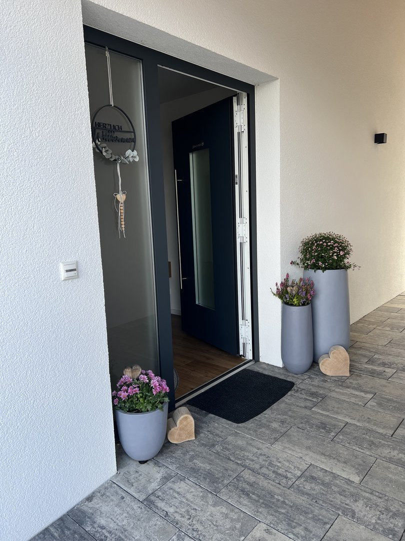 Pflanzkübel Fiberglas rund konisch D30xH30cm grau mit Chrysanthemen und Heide am Hauseingang