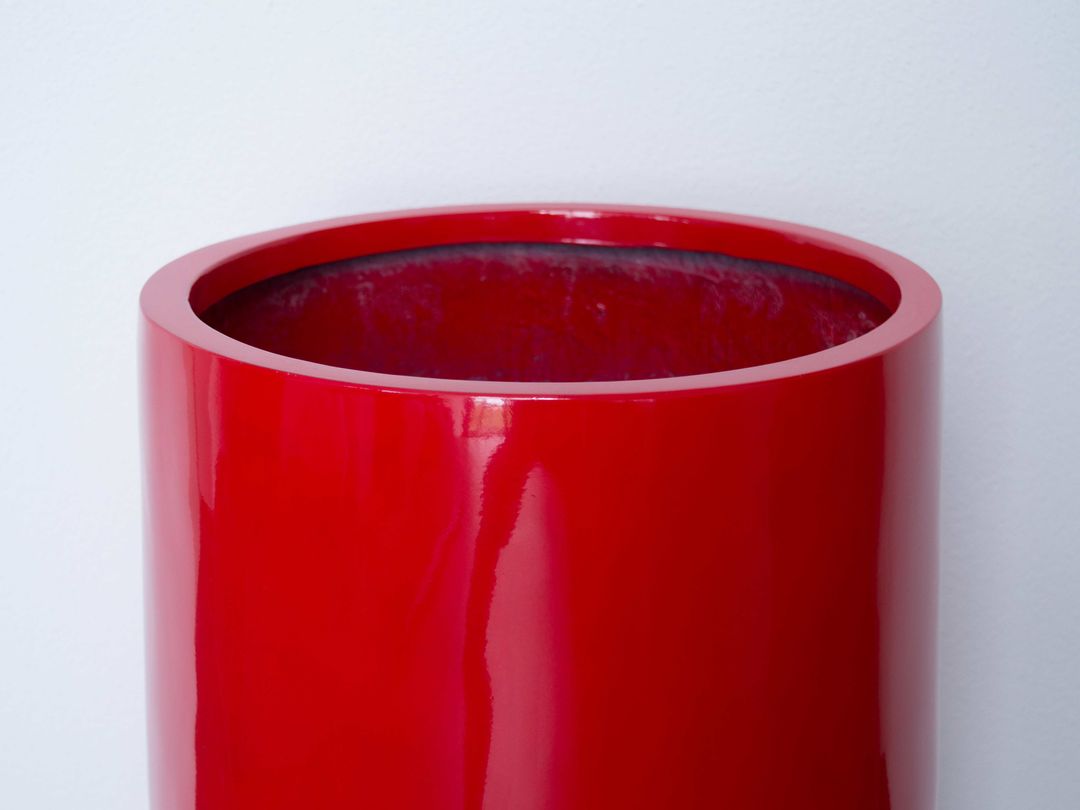Oberer Rand eines runden Pflanzkübels aus Fiberglas in Hochglanz Rot vor heller Wand mit Blick in die Öffnung