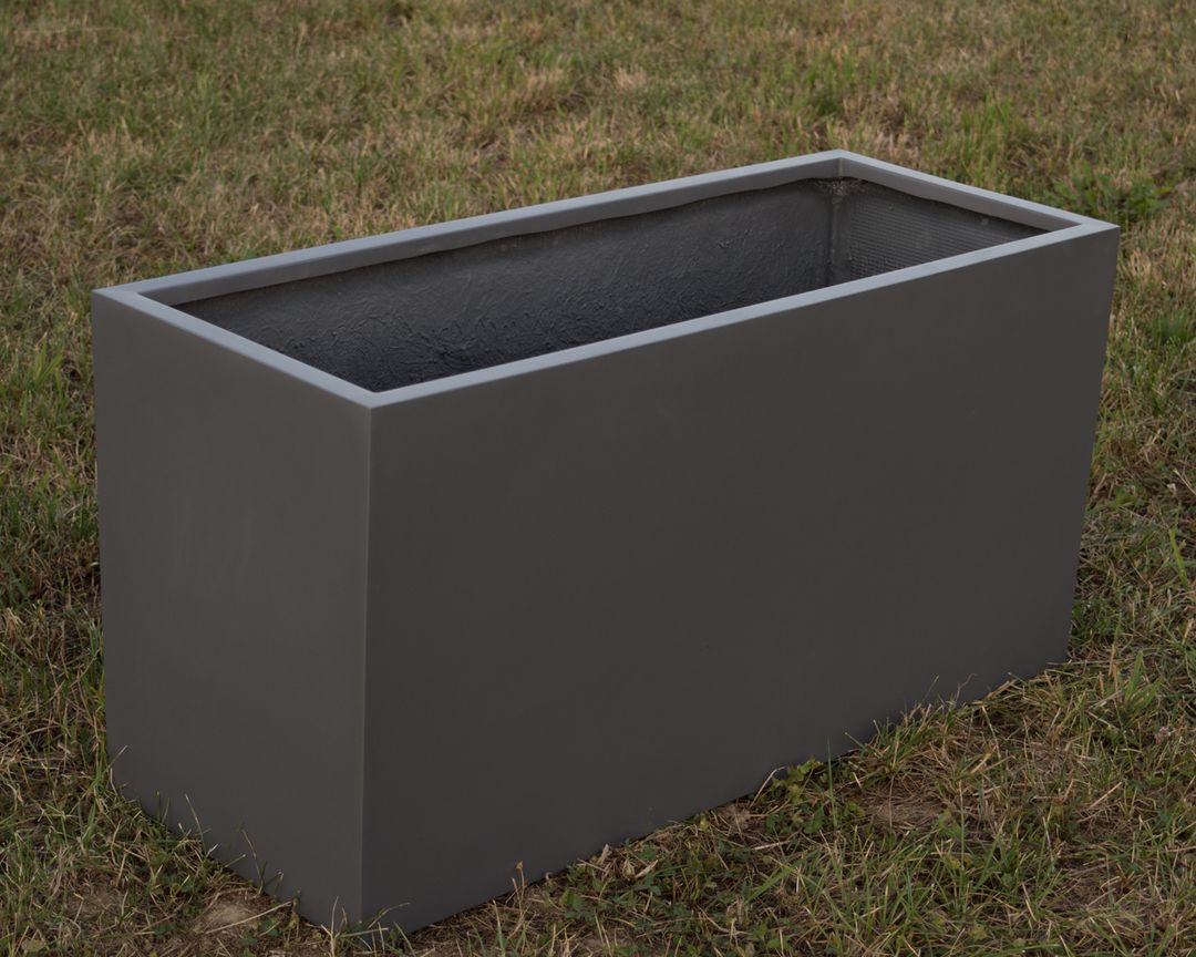 Leerer rechteckiger Pflanzkübel aus Fiberglas in Anthrazit metallic, schräg von oben auf einer Rasenfläche
