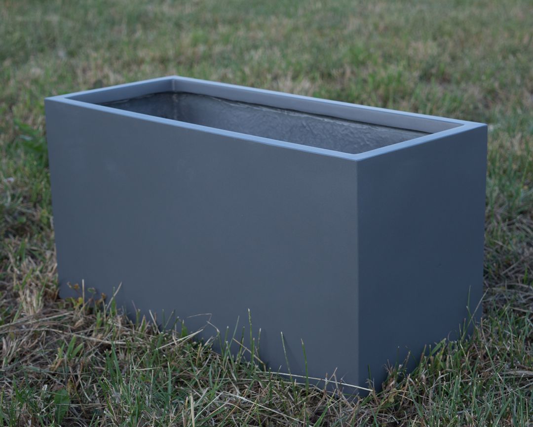 Rechteckiger Pflanzkübel aus Fiberglas in Anthrazit metallic, leer auf einer Rasenfläche stehend