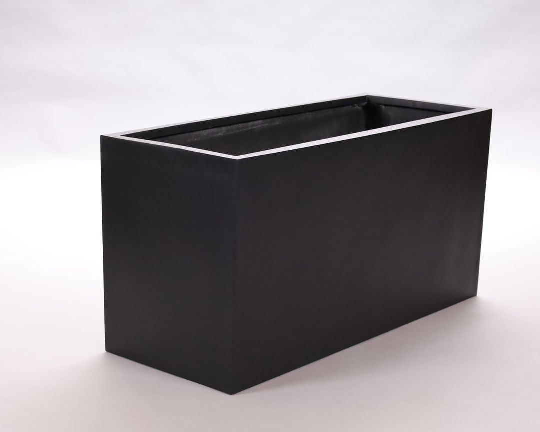 Rechteckiger Pflanzkübel aus Fiberglas in Schwarz-matt, leer und schräg von vorn vor hellem Hintergrund