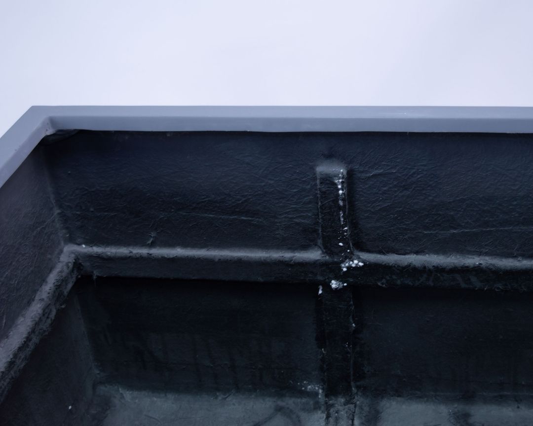 Detailansicht der Innenseite eines grauen Fiberglas-Pflanzkübels mit schwarzer Innenwand und Verstärkungsrippen