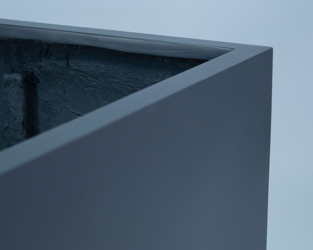 Nahaufnahme der oberen Ecke eines quadratischen Pflanzkübels in Anthrazit-Metallic mit Blick auf Rand und Innenseite