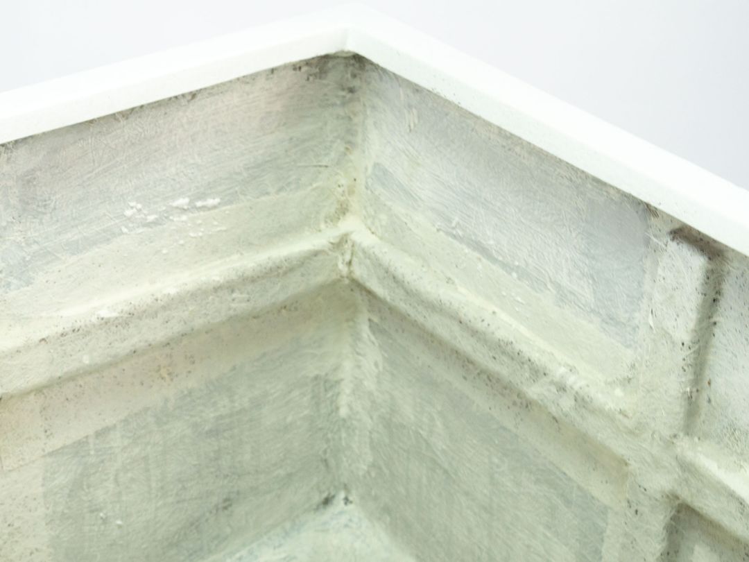 Blick in die Innenecke eines quadratischen Pflanzkübels in Perlmuttweiß mit hellem Rand und rauer grauweißer Innenwand