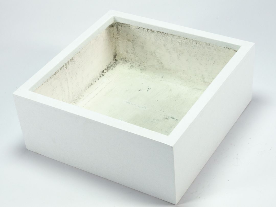 Niedriger quadratischer Pflanzkübel aus Fiberglas in Perlmuttweiß, schräg von oben mit Blick in den leeren Innenraum