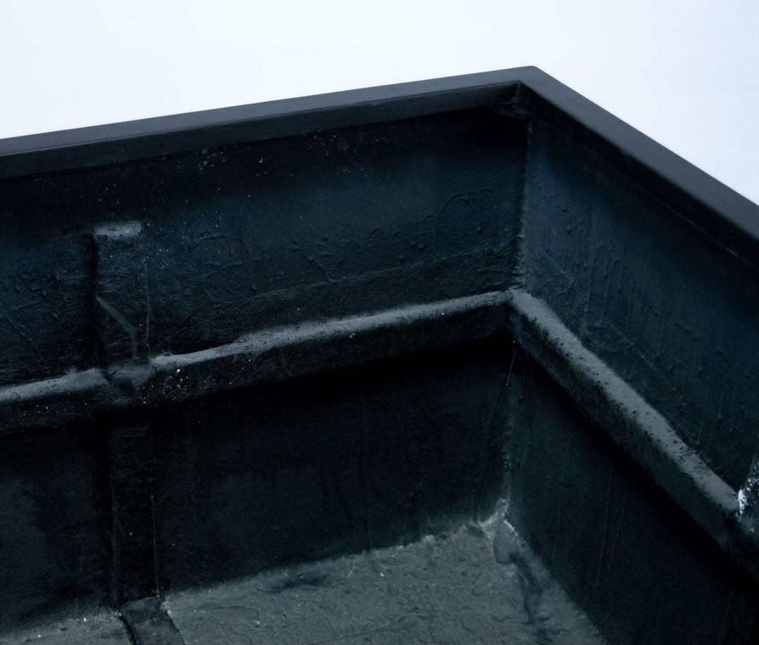 Innenansicht einer Ecke eines quadratischen Pflanzkübels aus Fiberglas in Schwarz-matt mit Rand und Verstärkungsleiste