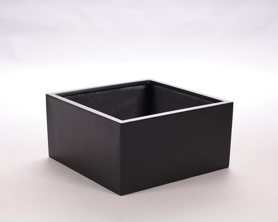 Niedriger quadratischer Pflanzkübel aus Fiberglas in Schwarz-matt, leer vor hellem Studiohintergrund