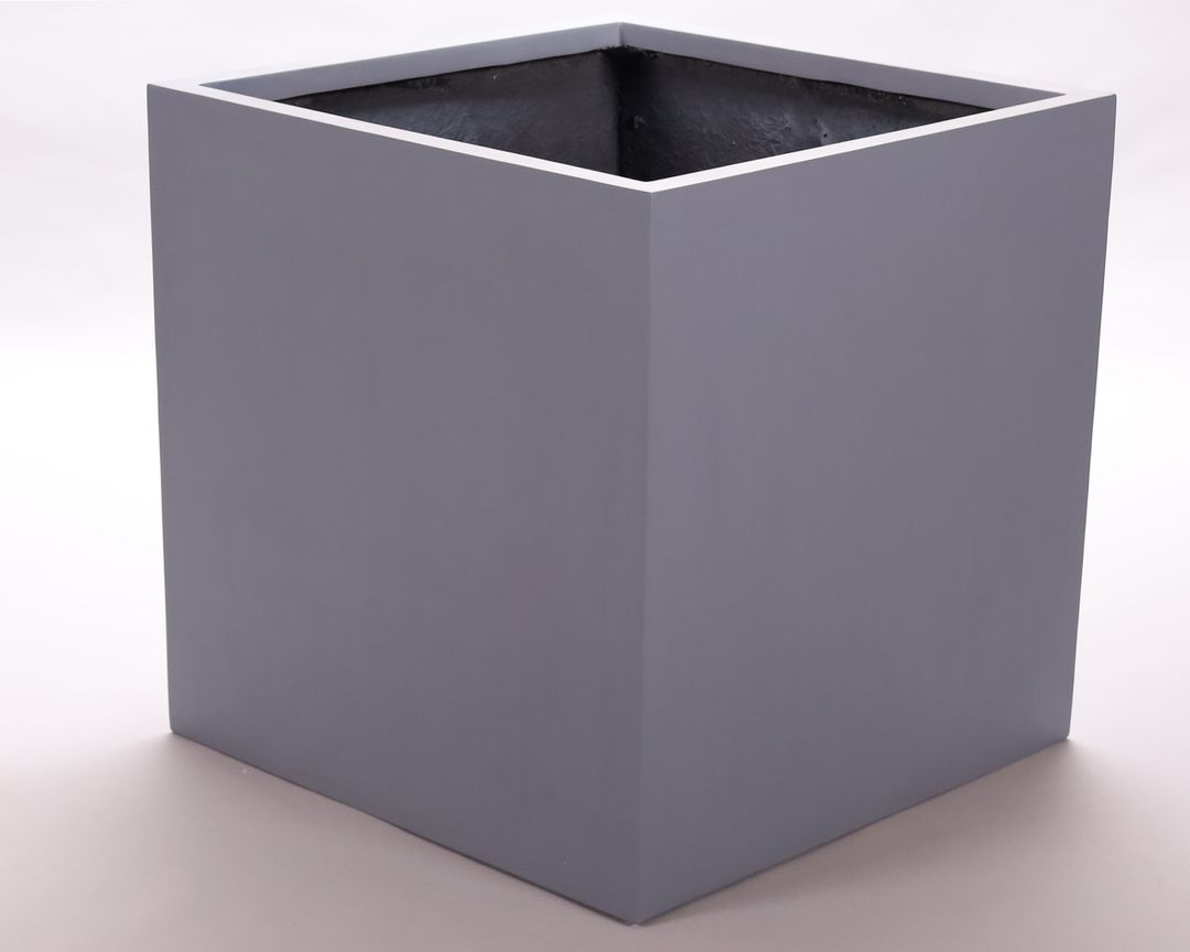 Leerer quadratischer Pflanzkübel aus Fiberglas in Grau, schräg von oben vor hellem Hintergrund