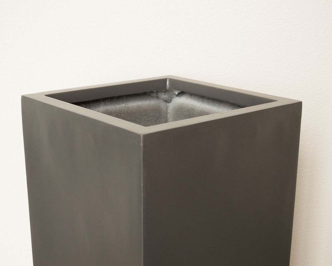 Detailansicht des oberen Rands einer quadratischen Pflanzsäule aus Fiberglas in Anthrazit metallic mit Blick ins Innere