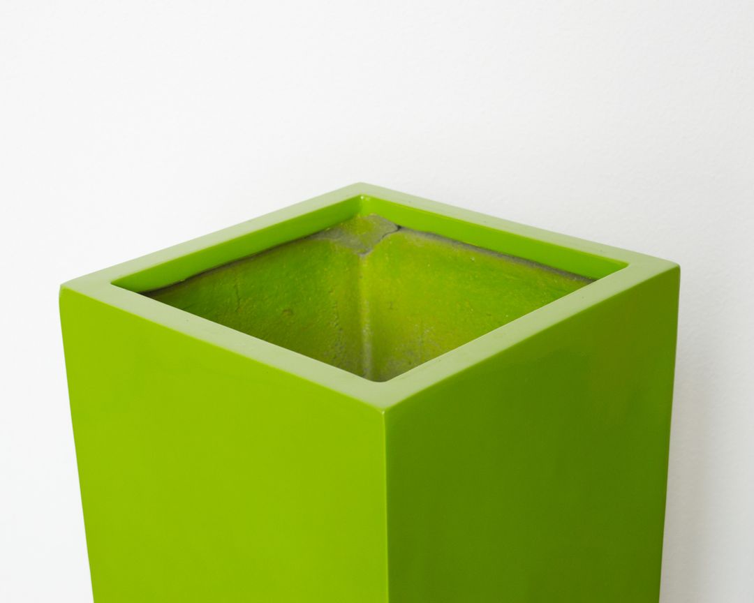 Detailansicht der offenen Oberkante einer quadratischen Pflanzsäule aus Fiberglas in Hochglanz Avocadogrün vor weißer Wand