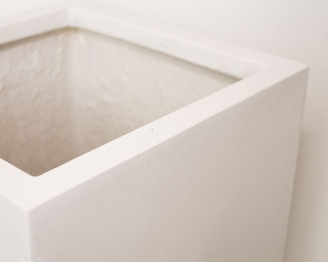 Detailansicht der quadratischen Oberkante eines Säulen-Pflanzkübels aus Fiberglas in Perlmuttweiß mit Blick ins Innere