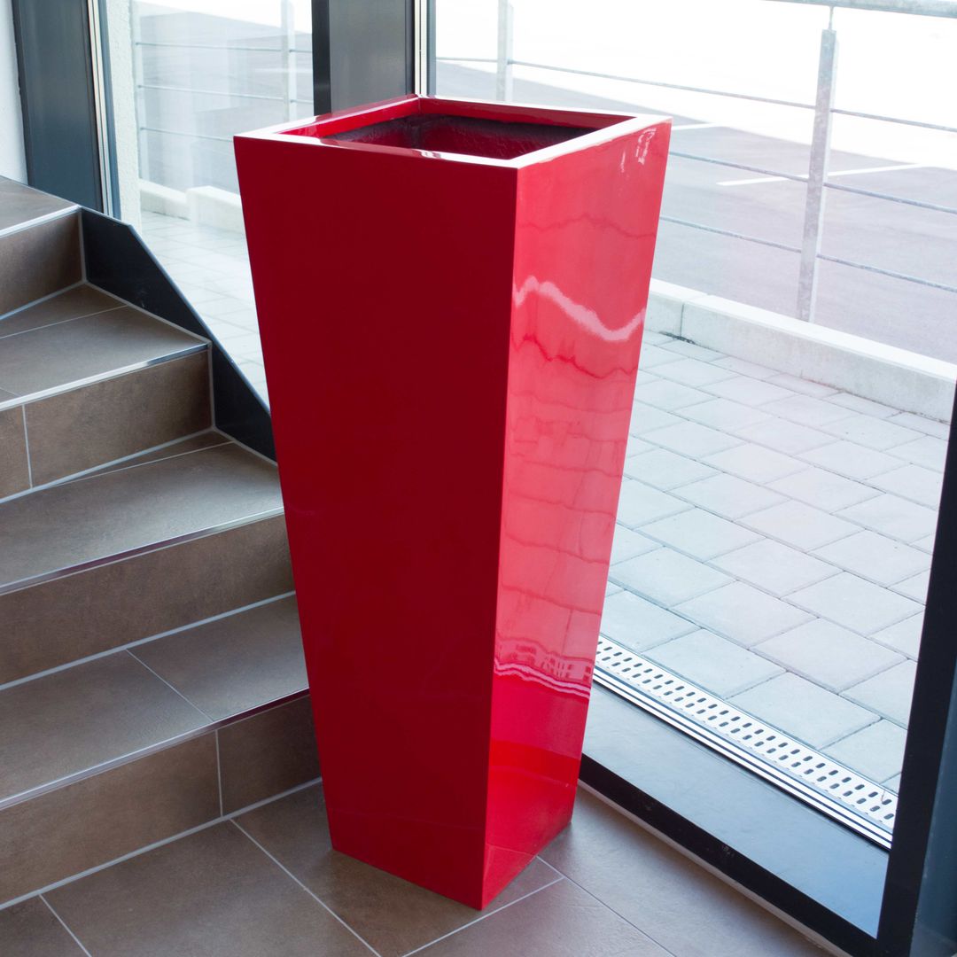 Konische Pflanzsäule aus Fiberglas in Hochglanz Rot, leer, neben einer Treppe vor einer großen Fensterfront
