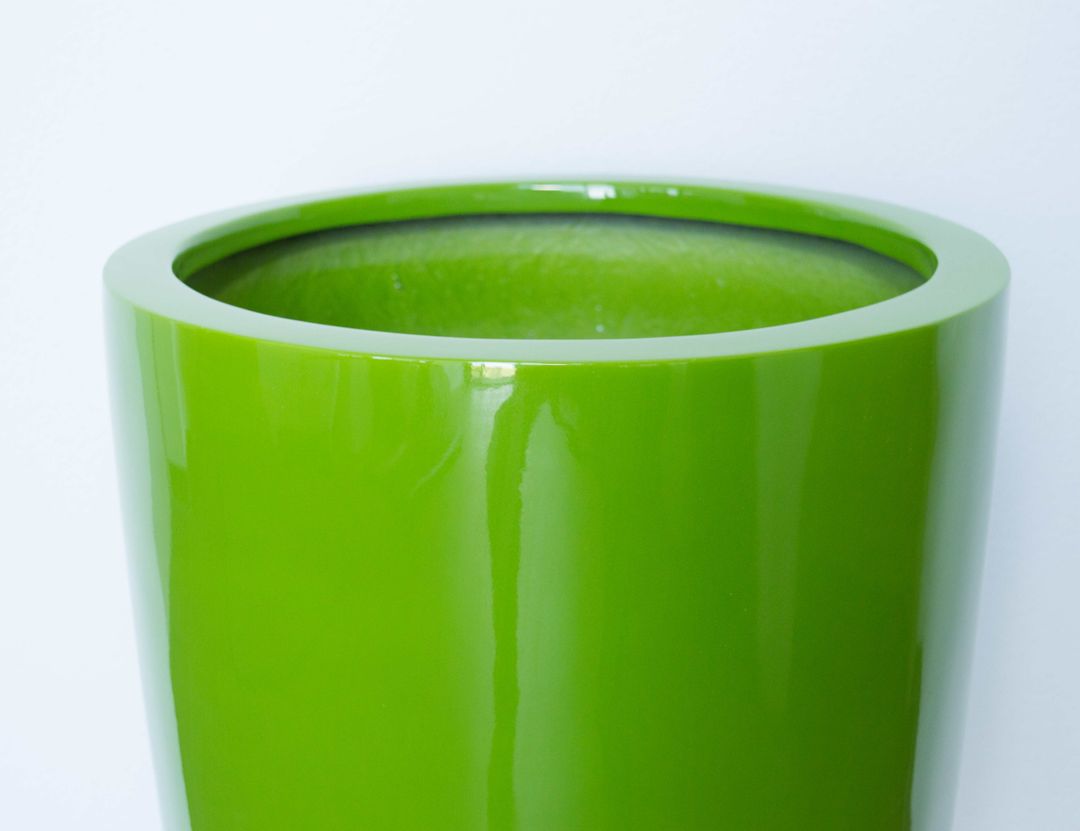 Nahaufnahme vom oberen Rand eines runden konischen Pflanzkübels aus Fiberglas in glänzendem Avocadogrün