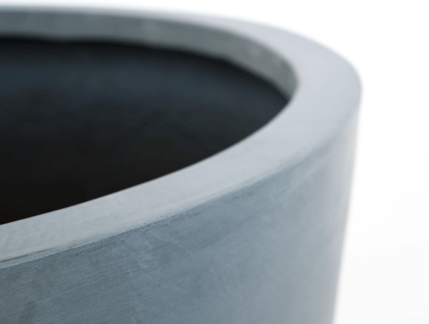 Nahaufnahme vom Rand eines runden grauen Pflanzkübels aus Fiberglas mit leicht gewischter Oberfläche