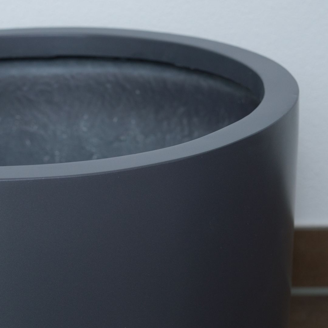 Nahaufnahme vom oberen Rand eines zylindrischen Pflanzkübels aus Fiberglas in Anthrazit-Metallic mit Blick ins Innere