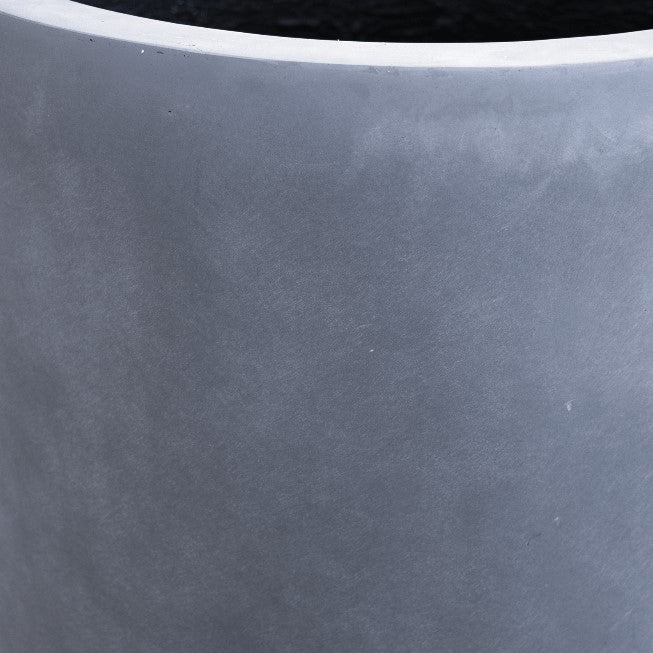 Nahaufnahme der grauen, matten Oberfläche und des oberen Rands eines zylindrischen Pflanzkübels aus Fiberglas