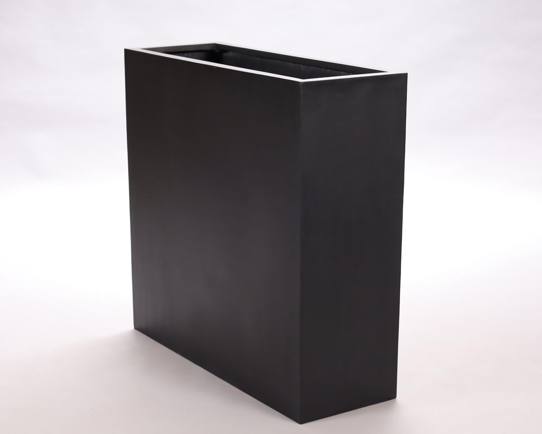 Schmaler, hoher rechteckiger Pflanzkübel aus Fiberglas in Schwarz-matt, schräg von vorne vor hellem Hintergrund
