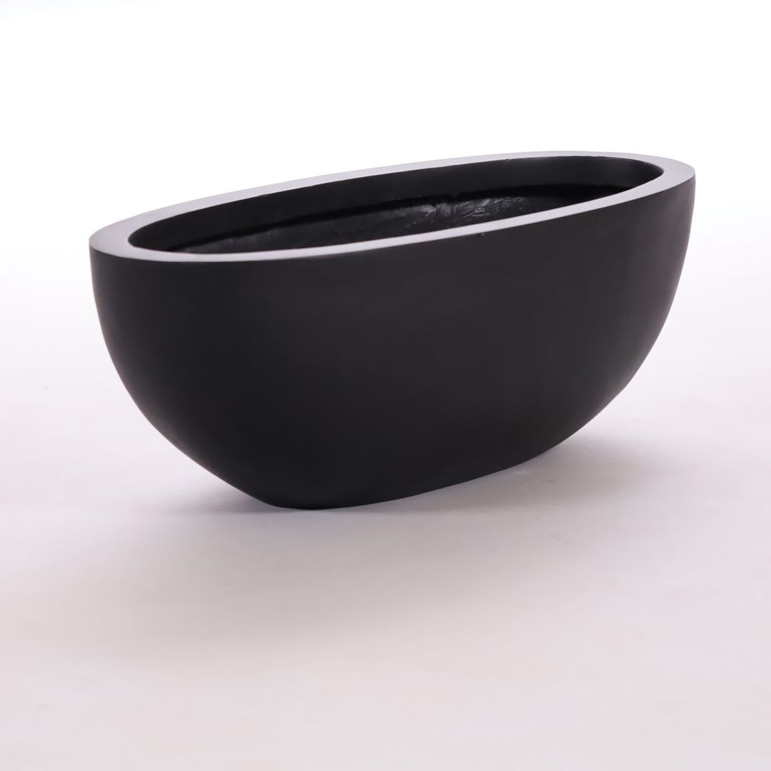 Ovaler Pflanzkübel aus Fiberglas in Schwarz-matt mit nach unten schmaler werdender Schalenform vor hellem Hintergrund