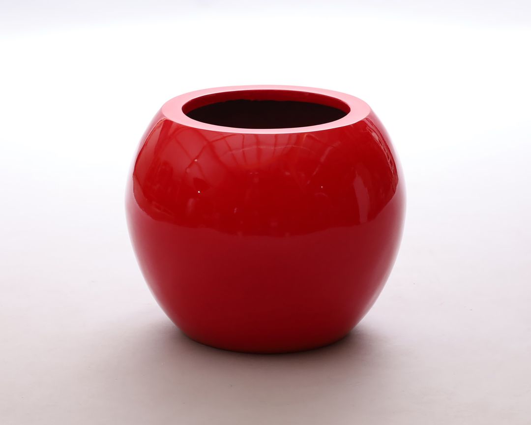 Runder Pflanzkübel aus Fiberglas in Kugelform, hochglanz rot mit runder Öffnung, vor hellem Hintergrund