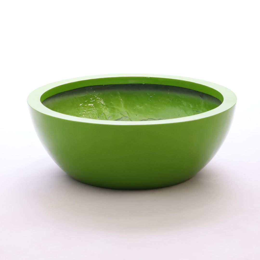 Runde, flache Pflanzschale aus Fiberglas in Hochglanz Avocadogrün mit breitem Rand vor hellem Hintergrund