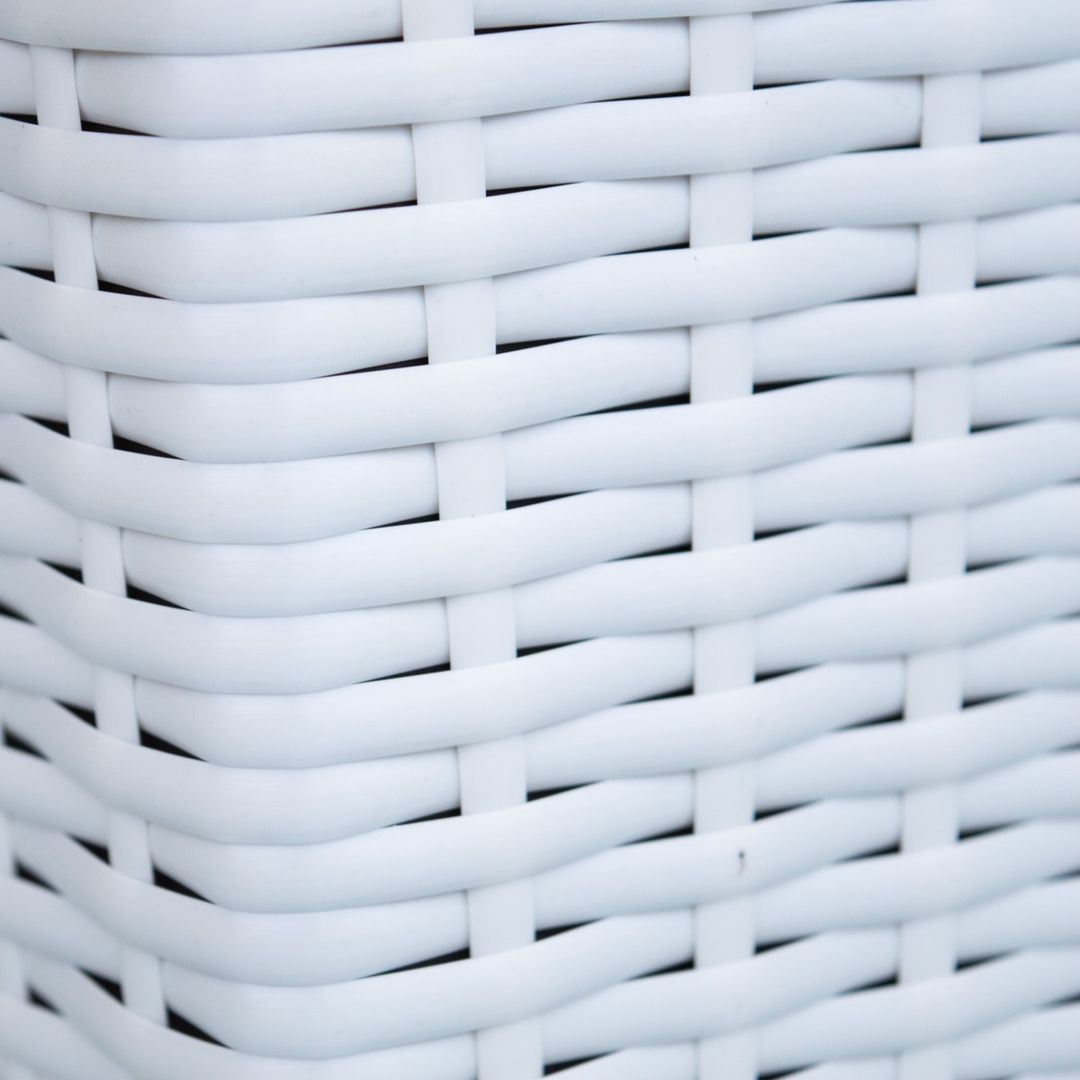 Nahaufnahme des weißen Polyrattan-Geflechts an der Ecke eines quadratischen Pflanzkübels mit breiten Flechtbändern
