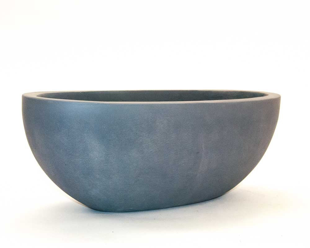 Ovaler Pflanzkübel aus Fiberglas in Grau als flache Schale in Seitenansicht vor hellem Hintergrund