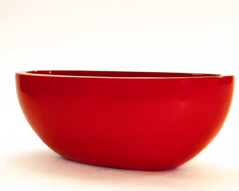 Ovaler Pflanzkübel aus Fiberglas in Hochglanz Rot, flache Schalenform mit gerundeten Seiten vor hellem Hintergrund