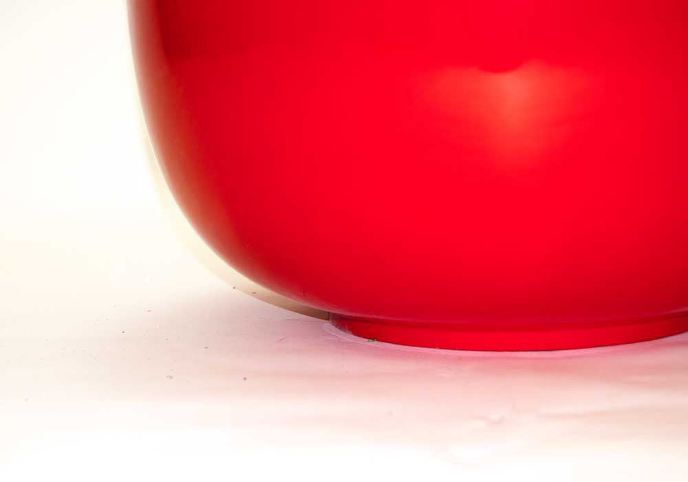 Nahaufnahme des unteren Bereichs einer runden Pflanzschale aus Fiberglas in Hochglanz Rot mit Standring